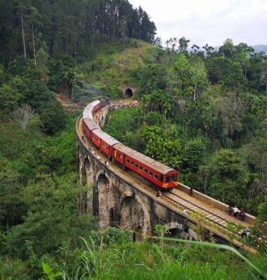 Trein op een stenen viaduct tussen groene heuvels, streamingdienst 24Trains