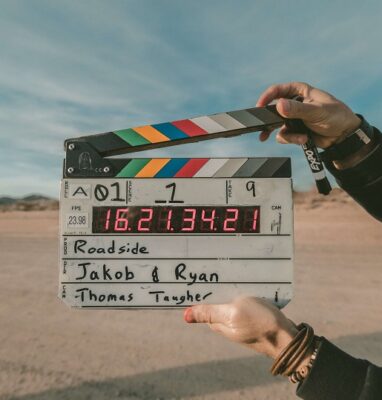 Hand holding a film clapperboard in the desert, Artfilm streaming case
