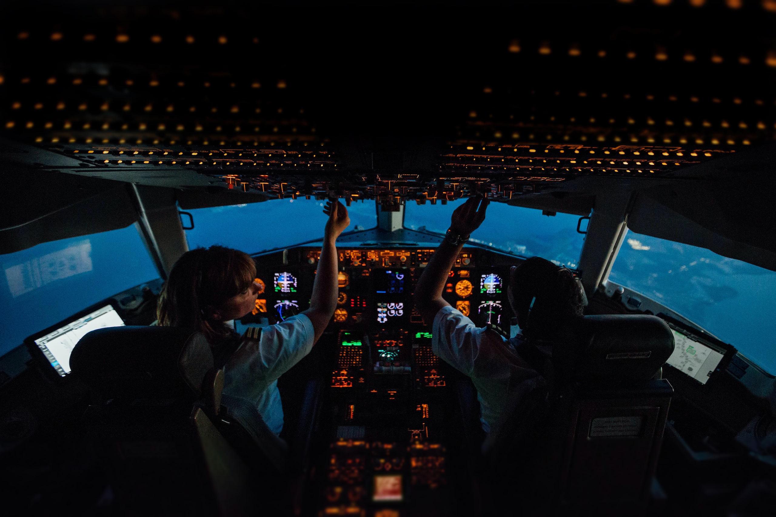 Pilots in an airplane cockpit at night