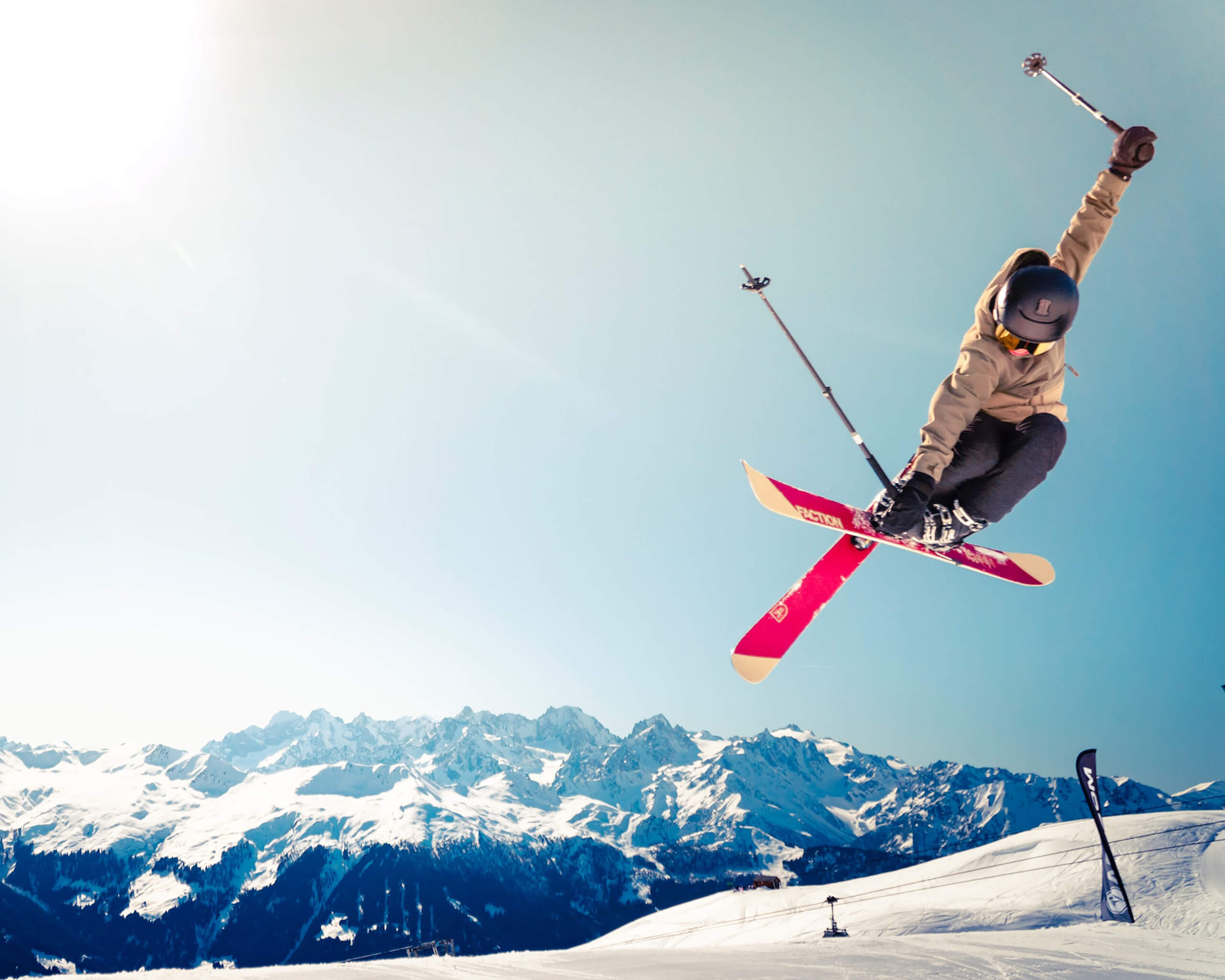 Skiër die springt tegen besneeuwde bergen, ter illustratie van sportstreaming