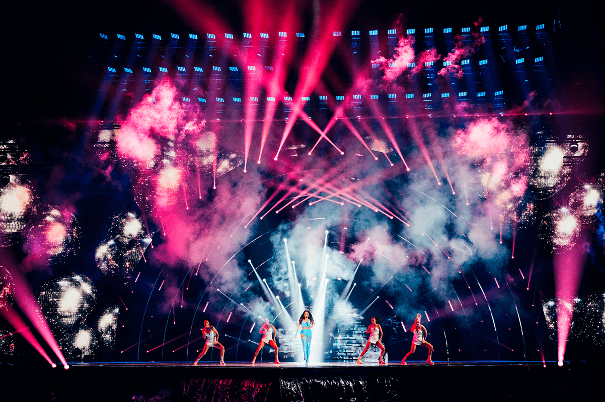 Podium van het Eurovisie Songfestival met roze lichten en vuurwerk