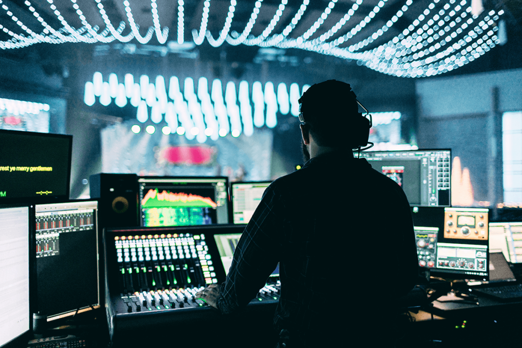 Engineer at a mixing console during a live event, broadcast grade live streaming