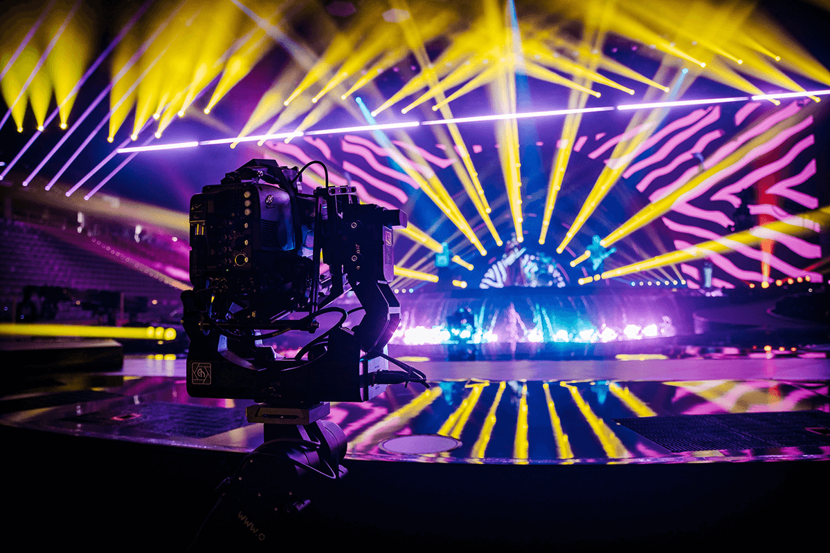Broadcastcamera die een concertpodium met lasers filmt, live streaming van een evenement