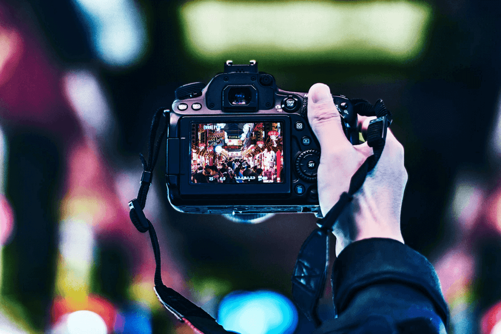 Hands filming a concert with a camera
