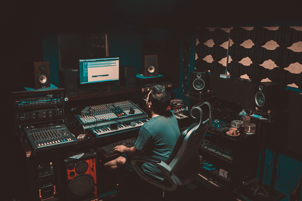 Radiopresentator achter een mengtafel in een studio voor radio streaming