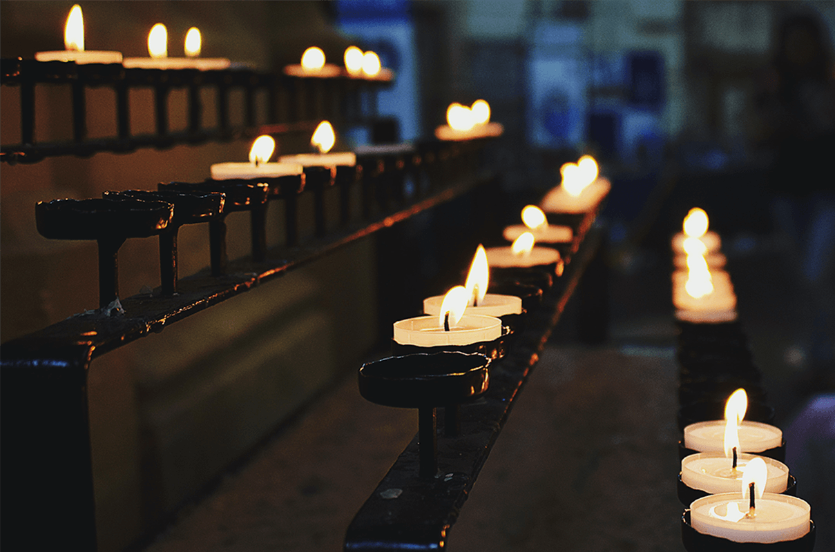 Rijen brandende kaarsen in een kerk, als illustratie van streamen voor kerk en geloof