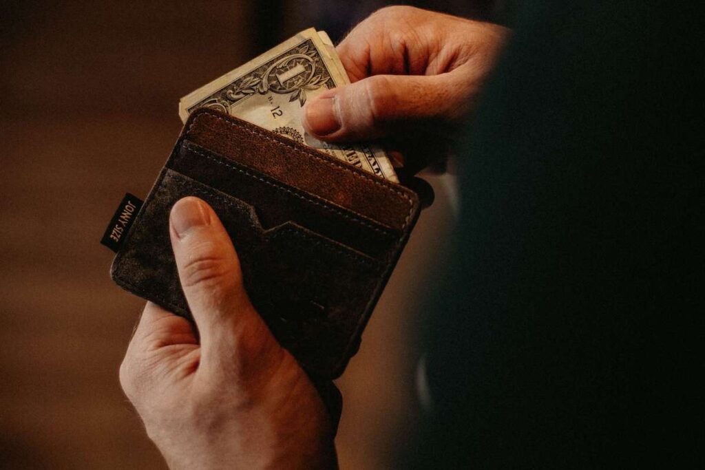 Hand die geld uit een portemonnee pakt, ter illustratie van besparingen met MaelStrom