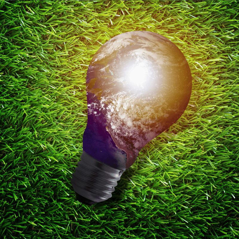 Light bulb with the Earth inside lying on grass, illustrating green streaming