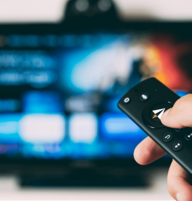Hand die een afstandsbediening op een tv richt, OTT-streaming met AudiencePlayer
